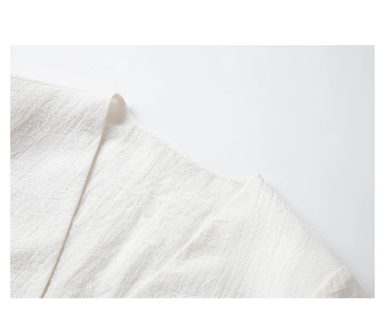 Detail of the V-neckline on a Pearl Bush textured pinstripe crinkle blazer. From Borcelleclothes.