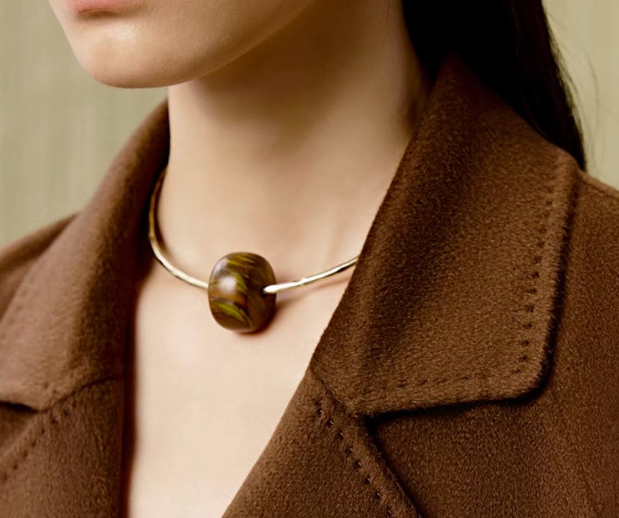 Model wearing the Women's Tibetan Cashmere Coat in Baker’s Chocolate, paired with a necklace, showcasing the notched lapels and refined upper design. From Borcelleclothes.