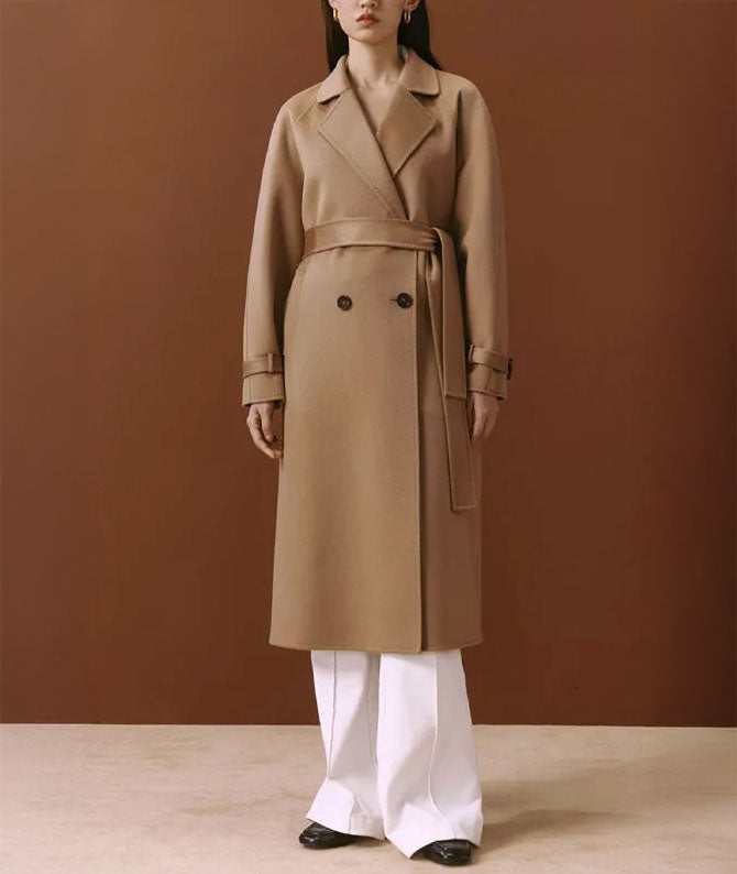 Women's Tibetan Cashmere Coat in French Beige, crafted from 100% double-sided Tibetan cashmere, featuring notched lapels, raglan sleeves, adjustable sleeve belts, a waist belt, and diagonally exposed single-welt pockets for a refined and luxurious look. From Borcelleclothes.