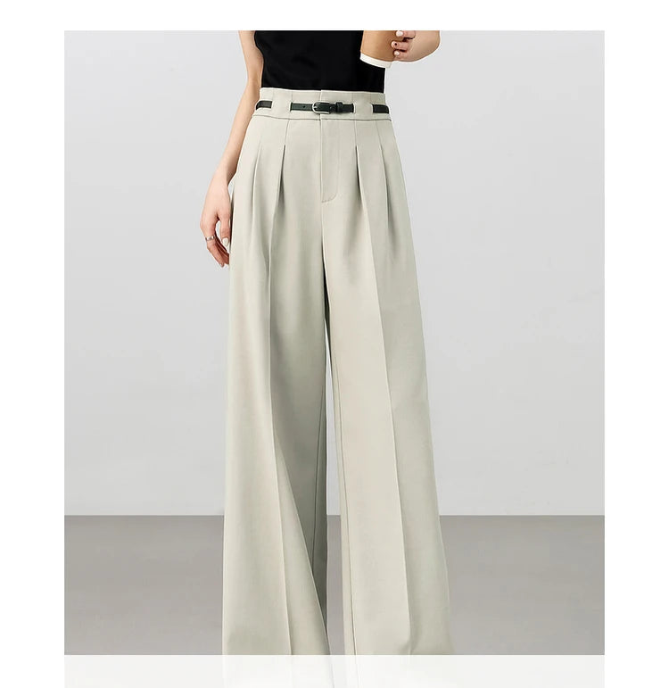 Model in foggy grey trousers holding a cup of coffee, blending elegance with relaxed, everyday sophistication. From Borcelleclothes.