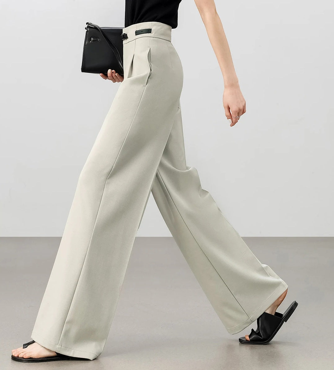 Side view of women’s tailored trousers in foggy grey, highlighting the soft drape and clean silhouette. From Borcelleclothes.