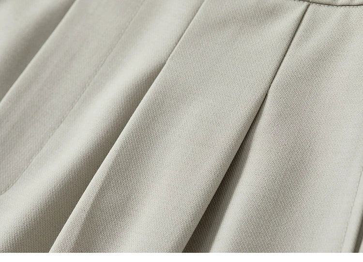 Close-up of the foggy grey trousers' deep front tucks, showcasing their sculptural structure and fabric texture. From Borcelleclothes.