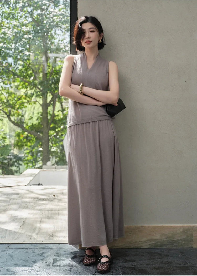 Model wearing the Morning Mist V-neck cashmere top, arms and legs crossed — From Borcelleclothes.