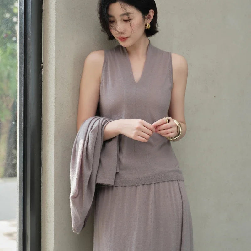 Model softly touching fingertips in the Morning Mist V-neck cashmere top — From Borcelleclothes.