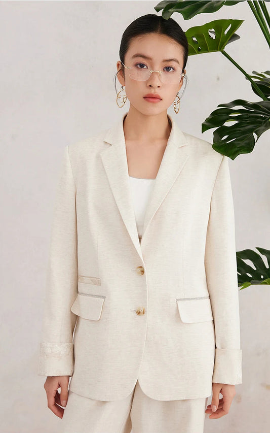Women’s White Coffee blazer worn with arms relaxed along the sides — showing the clean silhouette, straight lapels, and subtle jacquard cuff detail. From Borcelleclothes.