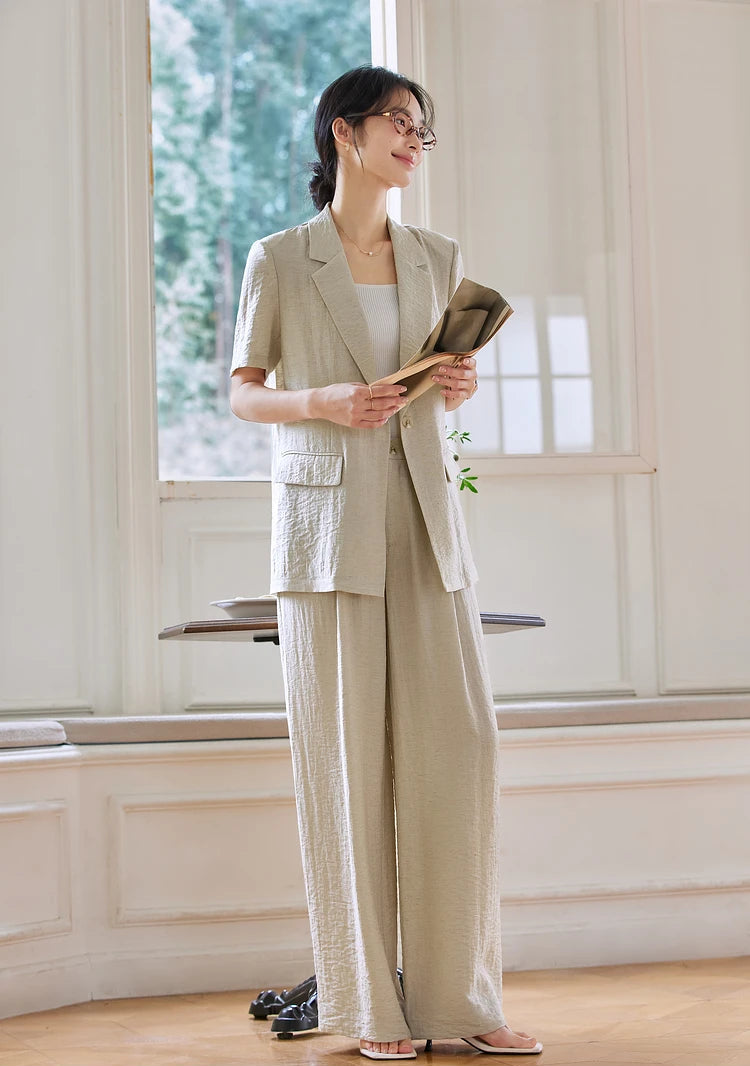 Model holding a rolled magazine while wearing the Wild Sand blazer and trousers. From Borcelleclothes.