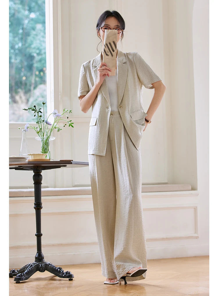 Model playfully covers part of her face with a magazine while wearing the Wild Sand set. From Borcelleclothes.