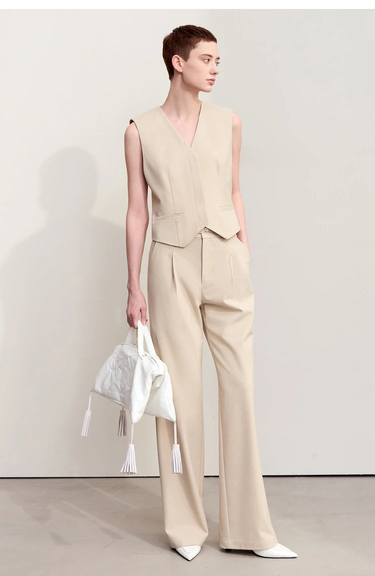A woman wearing a wool-blend minimalist trousers in Soft Amber looking to the side. — From Borcelleclothes.