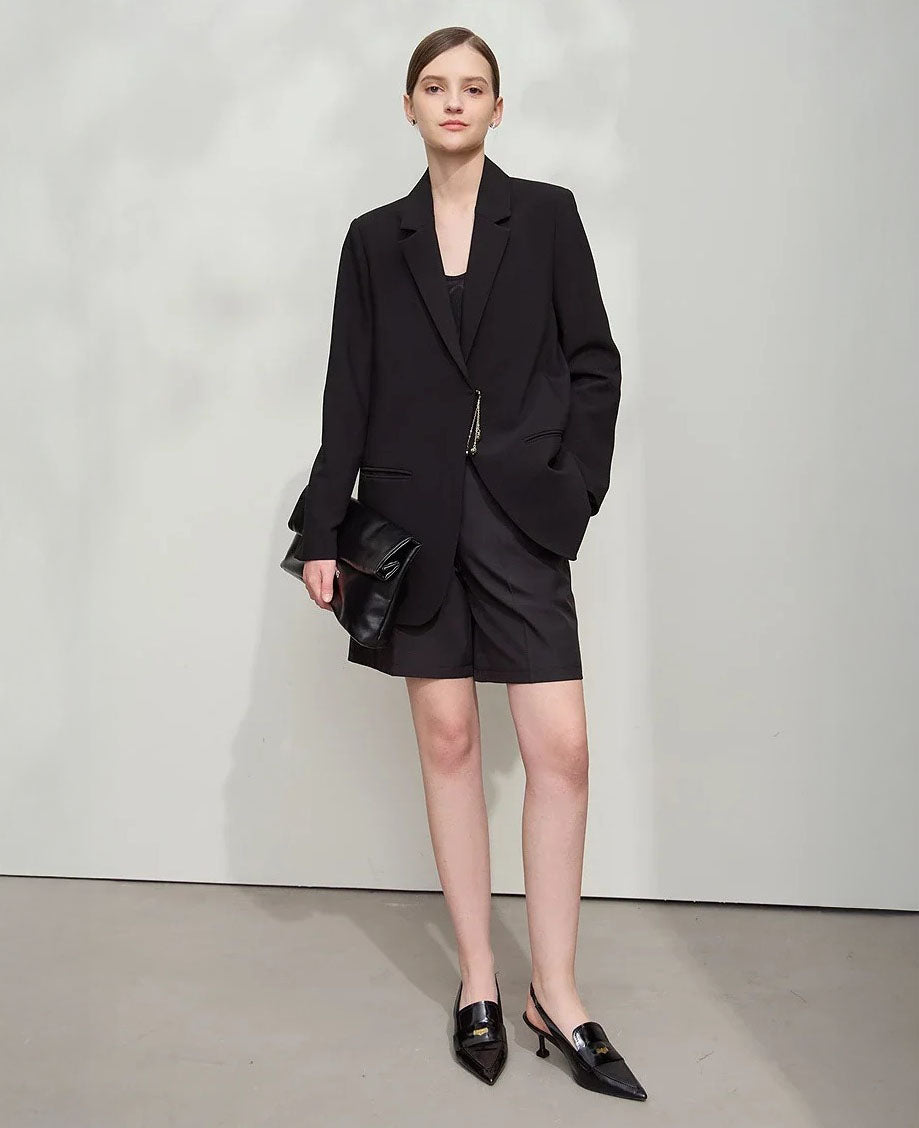 Women’s wrap blazer in Onyx, with hidden hook-and-eye closure, notch lapels, welt pockets, golden pendant accent, and thigh-length cut – From Borcelleclothes.