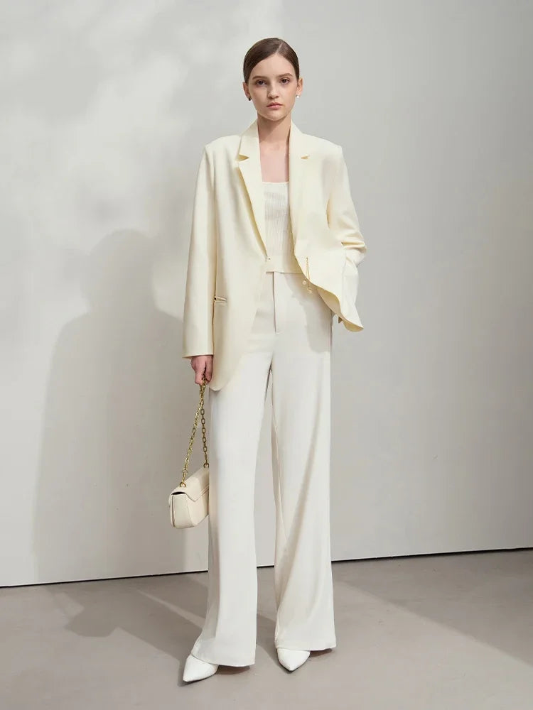 Woman with hand in pants pocket wearing Pearl Bush wrap blazer with golden pendant – From Borcelleclothes.