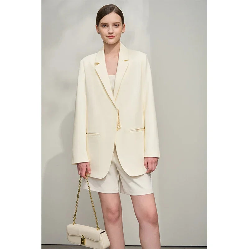 Woman holding matching color bag while wearing Pearl Bush wrap blazer with golden pendant – From Borcelleclothes.