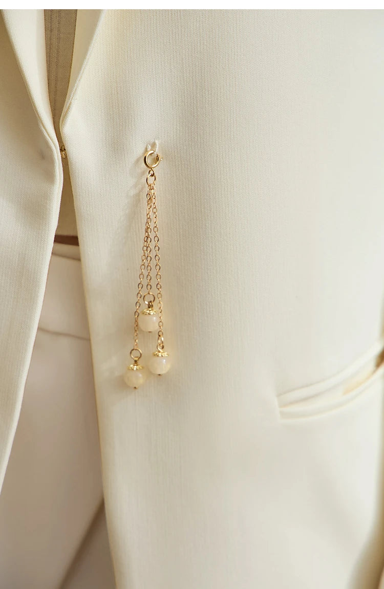 Waist section of women’s Pearl Bush wrap blazer with golden pendant – From Borcelleclothes.