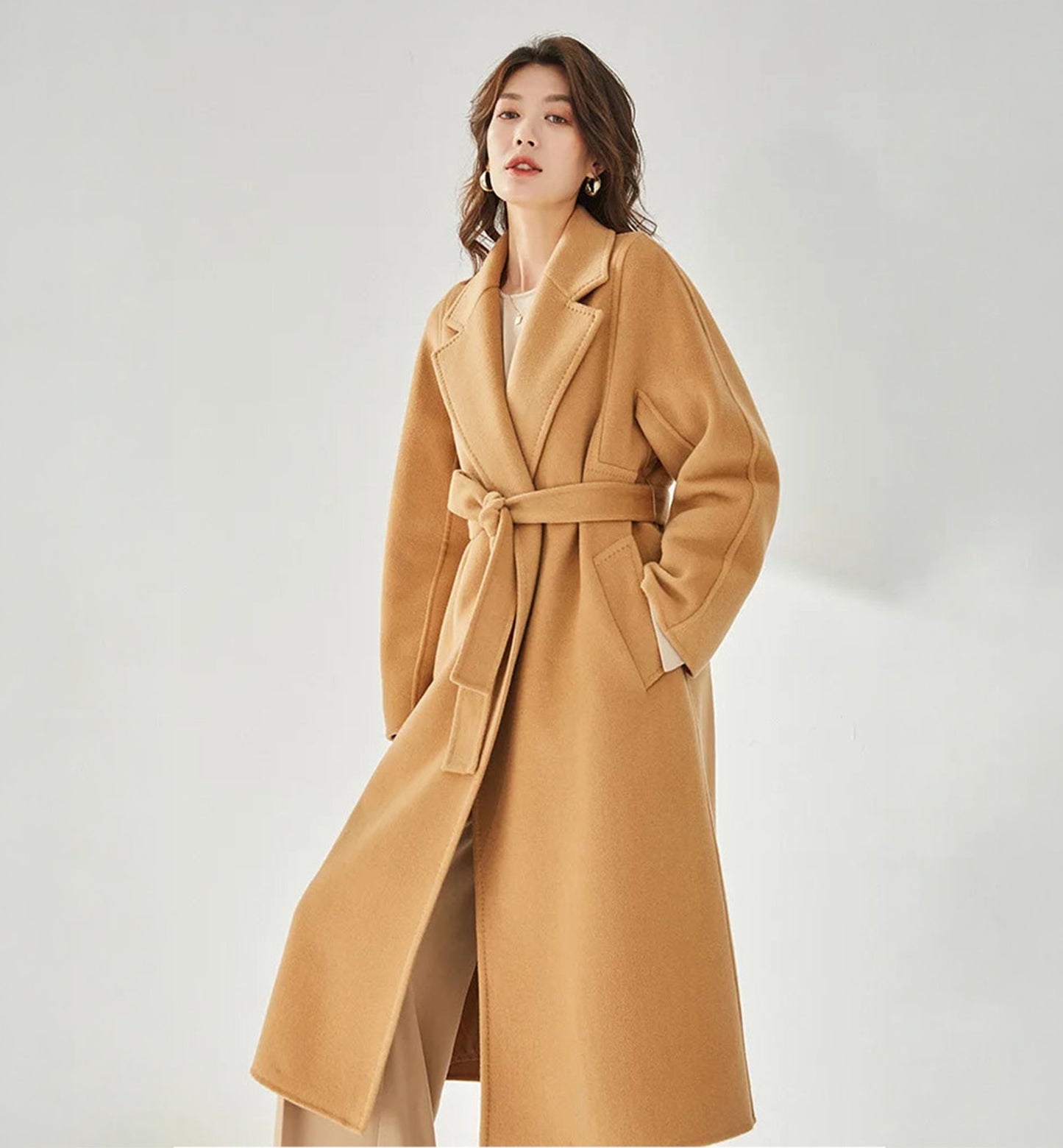 Women's Wrap Coat Redefined in Brown Sugar—crafted from a luxurious blend of Merino wool and cashmere. Featuring square gussets for a structured silhouette, notch lapels, a single-welt pocket design, and an adjustable belt, this mid-calf wrap coat blends modern tailoring with timeless elegance. From Borcelleclothes.