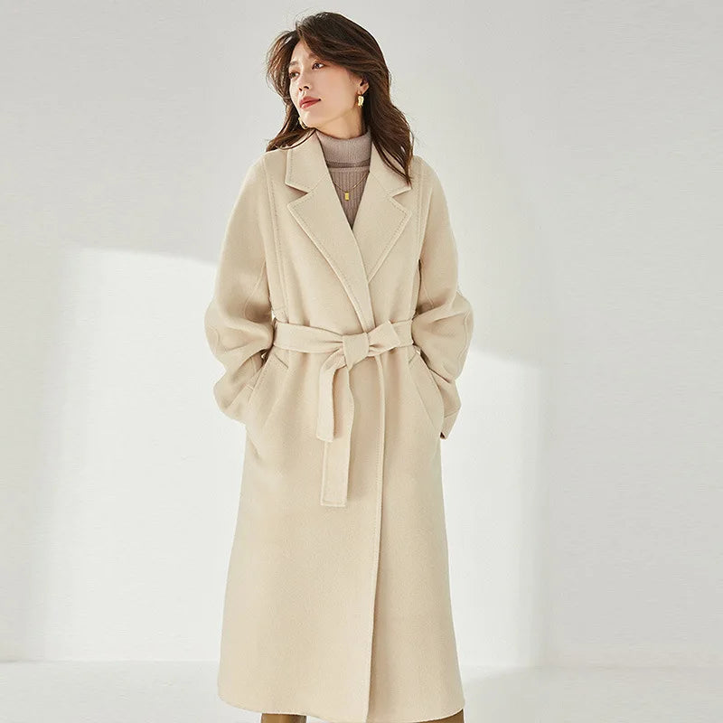 Women's Wrap Coat Redefined in Soft Amber—crafted from a luxurious blend of Merino wool and cashmere. Featuring square gussets for a structured silhouette, notch lapels, a single-welt pocket design, and an adjustable belt, this mid-calf wrap coat blends modern tailoring with timeless elegance. From Borcelleclothes.